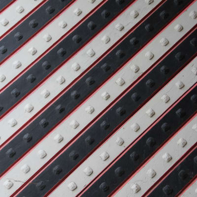 Metal door with diagonal black, white and red lines