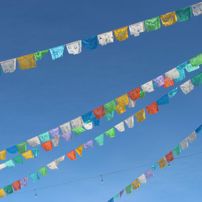 Colorful designed flags on a line with a blue sky