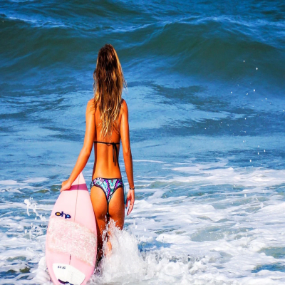 Girl Surfer going out to the ocean
